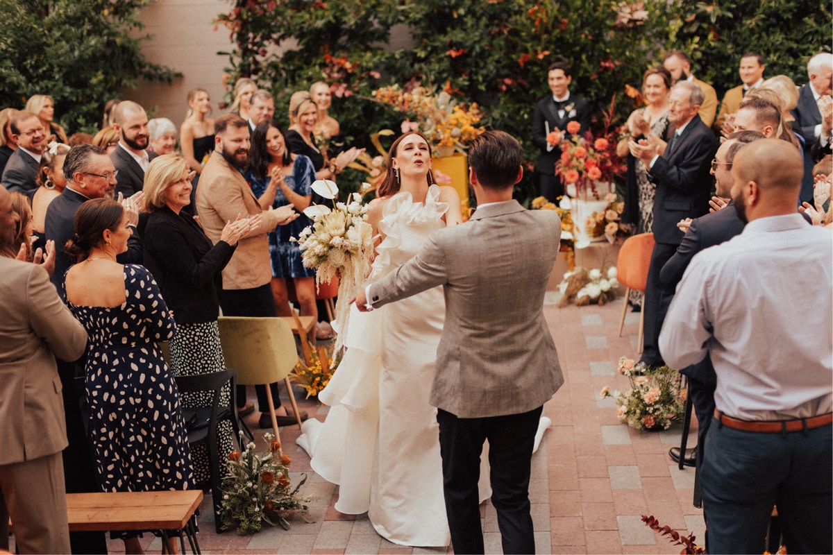 bride and groom dancing down the aisle at san diego wedding